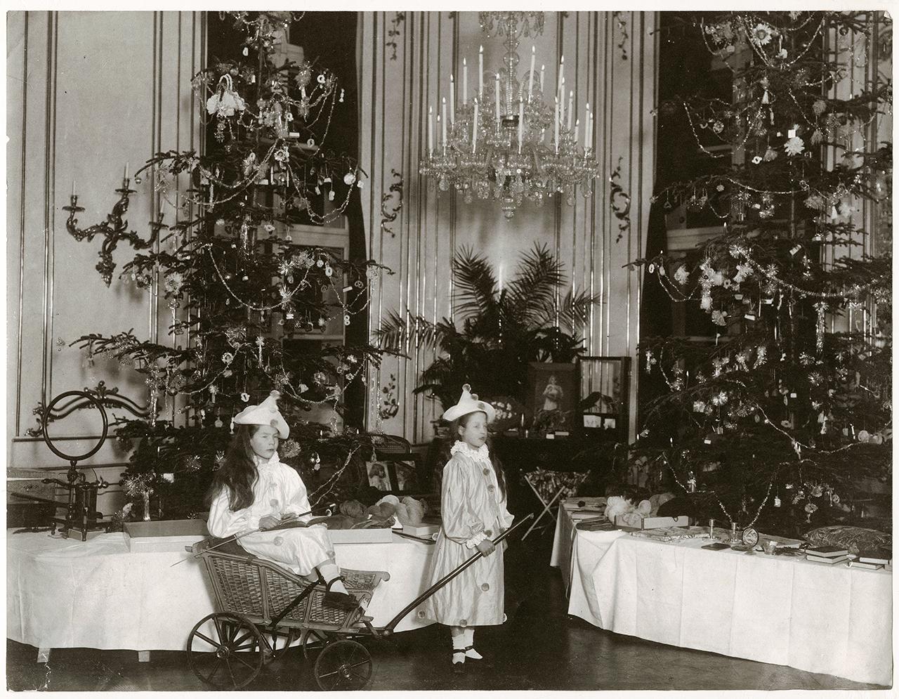 Frigyes főherceg és Izabella főhercegné két lánya, Izabella és Gabriella, jelmezben pózolnak a főhercegi palota karácsonyfái előtt. Pozsony, 1902 körül, ismeretlen fényképész felvétele, platinotípia 