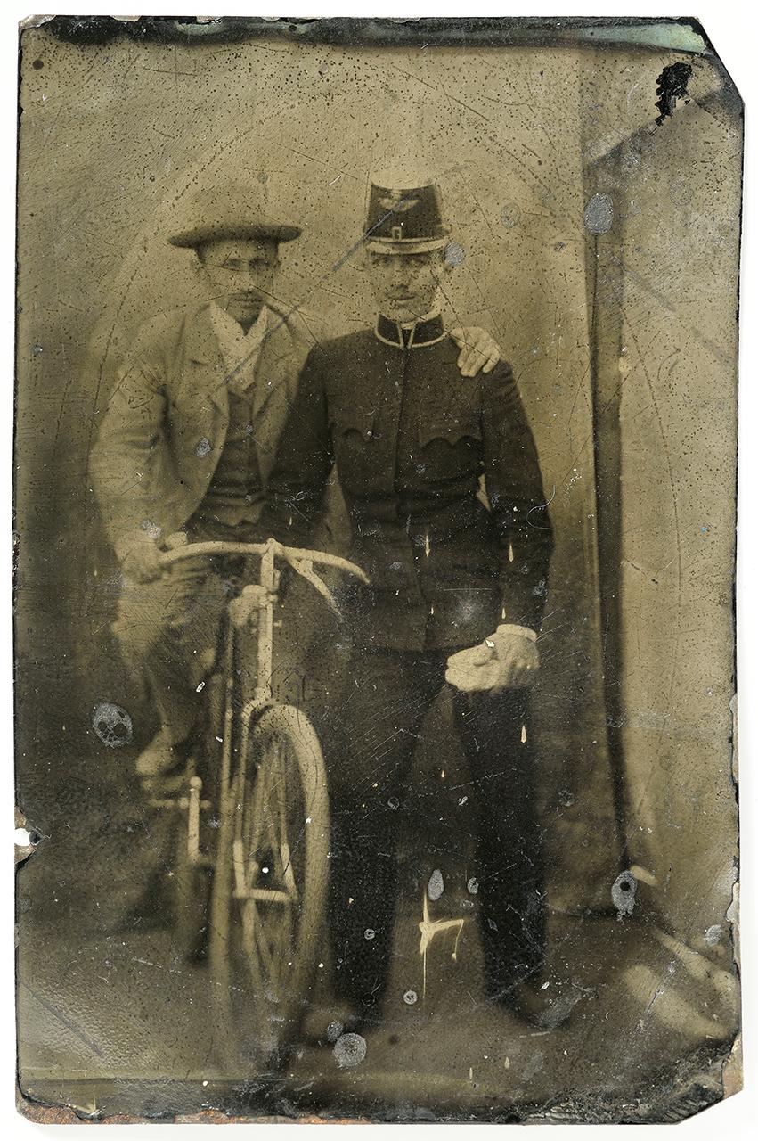 Vaslemezen vasparipa. Kerékpáron egyensúlyozó férfi vasúti egyenruhás társa vállába kapaszkodva pózol a kamerának. Ferrotípia, 1910 körül, ismeretlen fényképész felvétele 