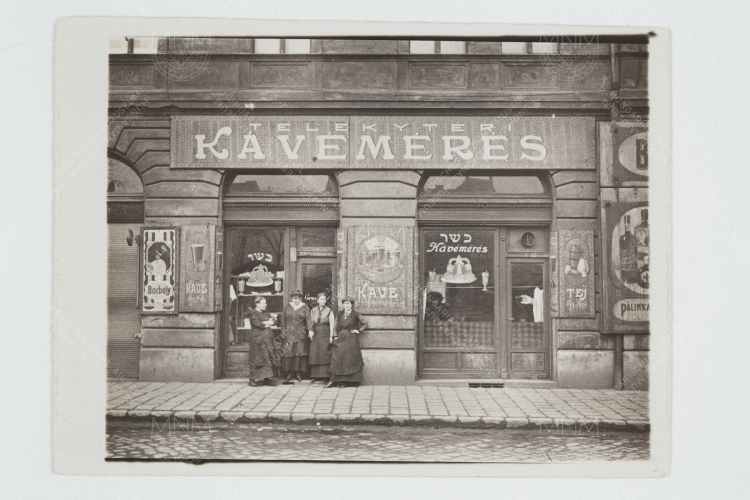 Kertész anyjának kávémérése, Budapest, Teleki tér, 1910-es évek. (A csoport bal oldalán Kertész édesanyja) ©Estate of André Kertész, Magyar Nemzeti Múzeum gyűjteménye