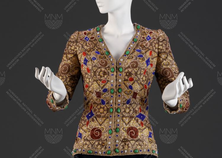 Ékszerkabát, lurex-viszkóz alapra üveg és teklagyöngyökkel készült kézi gyöngyhímzés, 1974. Az ékszerkardigánok divatját Yves Saint Laurent indította el, Rotschild Klára pedig megcsinálta a saját verzióját, mely haláláig az egyik legnépszerűbb kreációja volt. Magántulajdon